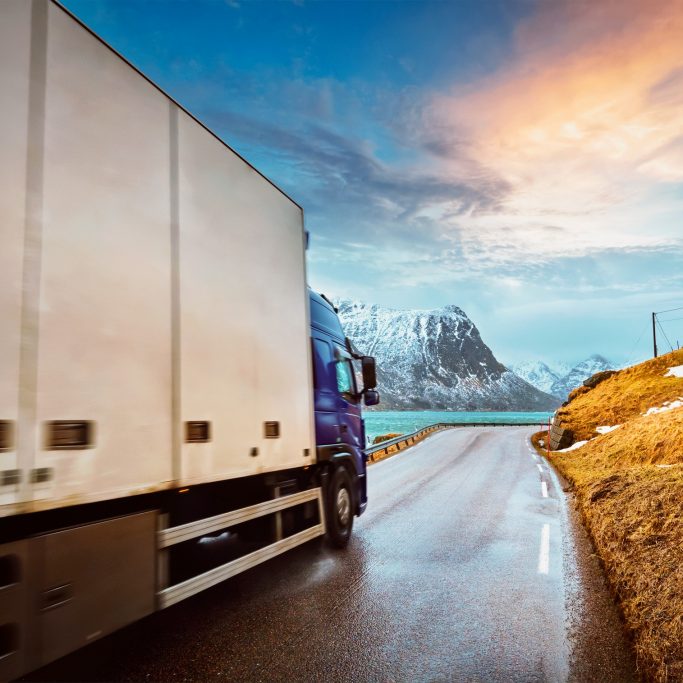 Truck on road in Norway Truck on road in Norwegian fjord on sunset. Lofoten islands, Norway. Motion blur